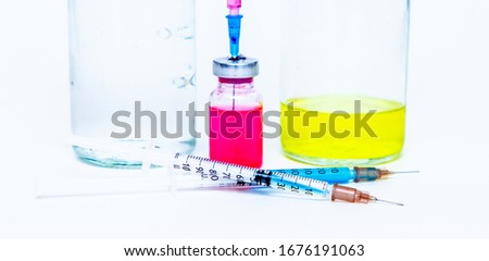 A bottle of pink medicine, a vaccine and a 3 ml plastic syringe with a needle isolated on a white background.
