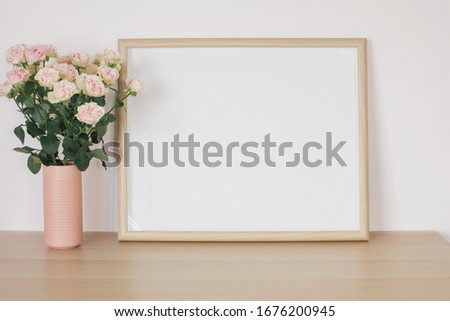 Mock up frame and fresh roses in vase. Minimal modern interior design concept. 