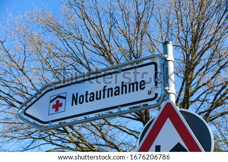 Isolated direction sign with red cross for hospital emergency department (german word: Notaufnahme) - Germany