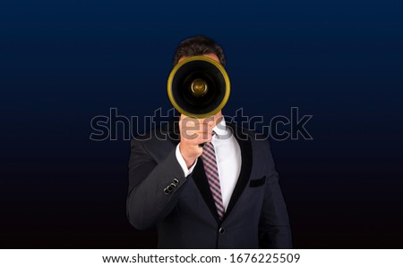 Businessman holding electric megaphone in front of his face