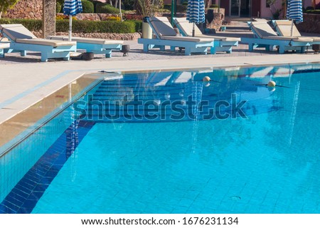 Chaise longues near a swimming pool. Concept of spa, rest, relaxation, holidays, resort