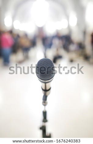 Shallow depth of field (selective focus) image with a microphone in front of TV cameras during a press conference.