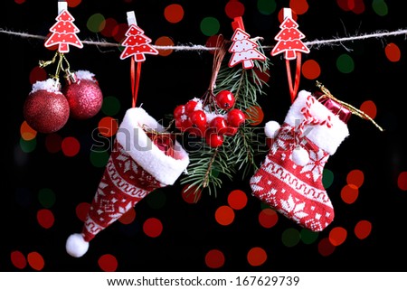 Santa sock, hat and Christmas accessories on black background with lights