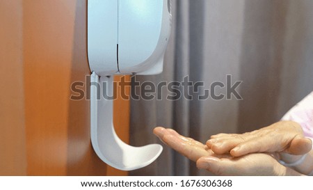 Senior patient woman washing her hand from automatic hand sanitizer in hospital, healthcare and prevention of pandemic Covid-19 and Coronavirus