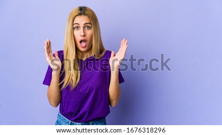 Young blonde woman isolated on purple background surprised and shocked.