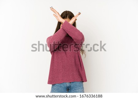 Young caucasian woman isolated on white background keeping two arms crossed, denial concept.