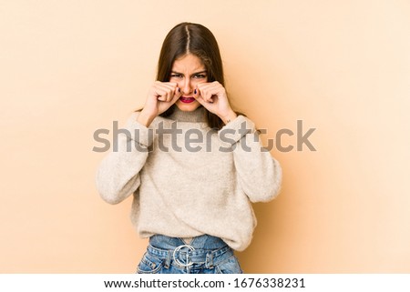 Young caucasian woman isolated en beige background whining and crying disconsolately.