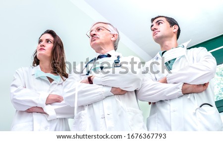 Young and senior doctors ready to fight against coronavirus outbreak at hospital clinic - Medical emergency concept about worldwide virus contagion spread - Bright neutral filter Royalty-Free Stock Photo #1676367793