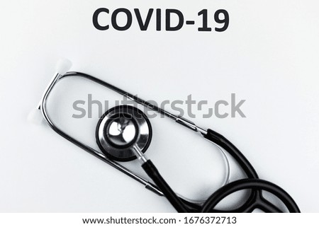 covid-19 and a stethoscope on a light background