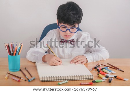 child drawing on a table on white background