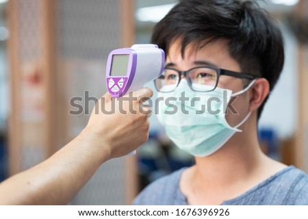 A thermometer Scan Fever And Symptoms of Coronavirus at College , School , Office , Mall , Hospital Royalty-Free Stock Photo #1676396926