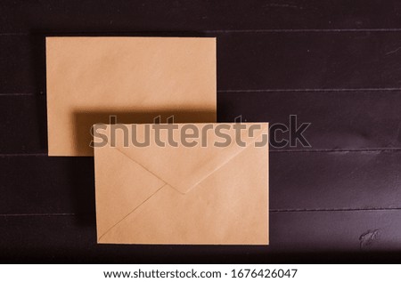 Two brown envelopes on a black wooden background