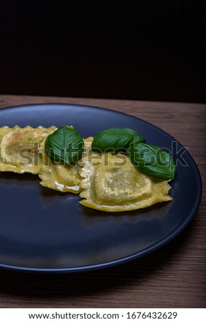 Pasta tortellini served in a plate with basil leaves