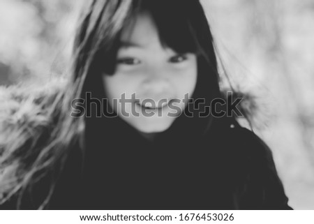 Black and white. Blurred and closed up a happy little girl in winter outfit