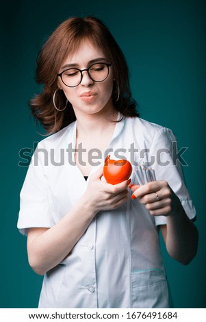 Young european cardiologist holds a toy red heart, showing that people monitor their health and did not use nicotine