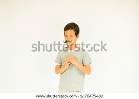 Young happy boy making mustache gesture
