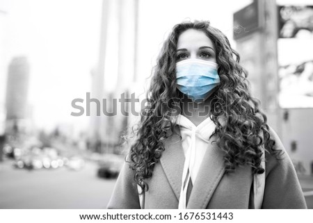 Black and white foto of girl in protective sterile medical mask on the street. Woman, wear face mask, protect from infection of virus, pandemic, outbreak and epidemic of disease in quarantine city. 