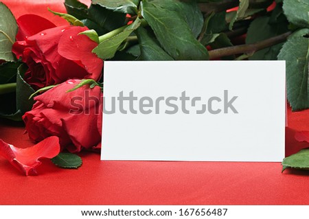 red roses and white card with a place for a congratulatory text
