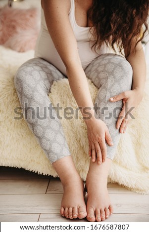 pregnant women with swelling of the legs, pain in the legs and lying on the bed in the room. Swollen feet in a pregnant woman for 9 months Royalty-Free Stock Photo #1676587807