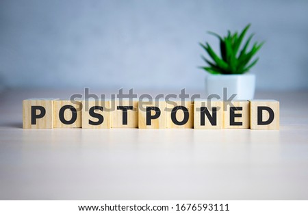 Postponed - words from wooden blocks with letters, postponed concept, top view background Royalty-Free Stock Photo #1676593111