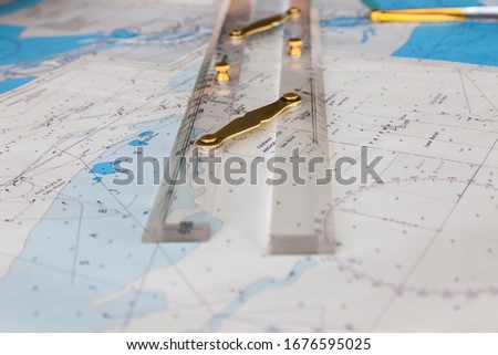 Maps of the ship and on them a ruler and divider for plotting the course.