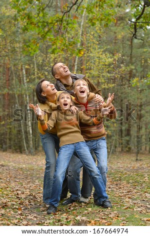 Family of four walking  in autumn forest