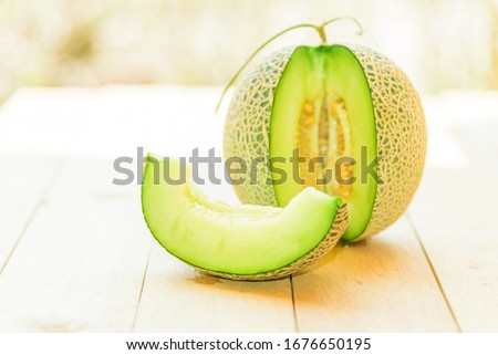 Fresh green melon on wood plate Royalty-Free Stock Photo #1676650195