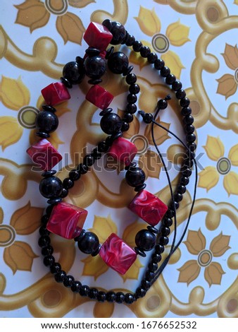 red black necklace on a ceramic floor. kalung Royalty-Free Stock Photo #1676652532