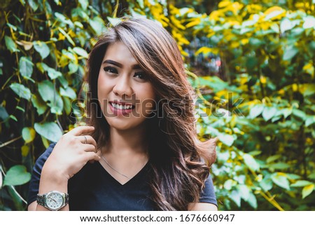 Young female wearing black t shirt do a posing in the park. Suitable for mock up design template