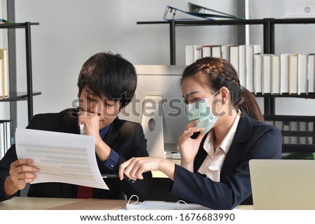 Male and female employee or business man and business women wearing surgical medical face mask while working in office for protect coronavirus and covid-19