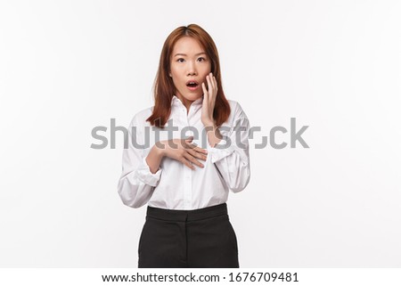 Portrait of shocked startled asian female gossiping, found out dirty little secret, open mouth and touch cheek impressed staring camera, heard rumor and react with disbelief, white background