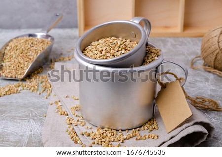 Green buckwheat grains in a dish on a slate background. The concept of healthy eating. Selective focus.