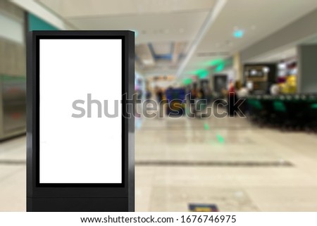 Standing Light box digital poster signage inside a shopping retail mall with blurred background people. Indoor Advertisement space