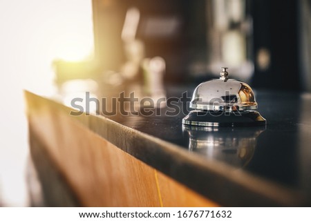A front desk bell on reception counter. Hotel bell is normally use to call staff service and staff can help guests with any queries that they may have. Royalty-Free Stock Photo #1676771632