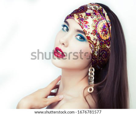 young pretty modern girl with bright shawl on head emotional posing isolated on white background, asian people ethnicity