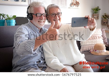 German text saying "stay home, everything will be fine". Two elderly people in contact with the family over the phone stay at home to avoid coronavirus infection. COVID-19 and quarantine concept Royalty-Free Stock Photo #1676797525
