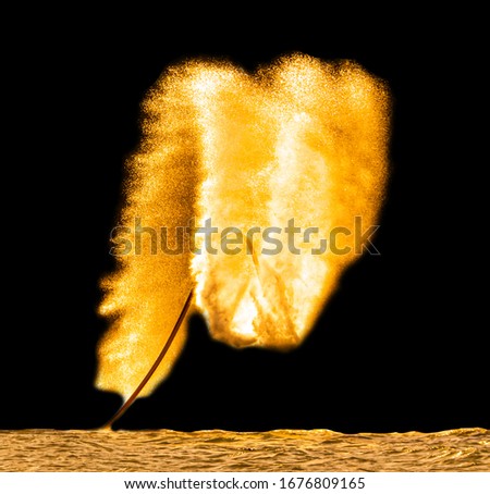 Man on a ride in splashes of golden water isolated on a black background.
