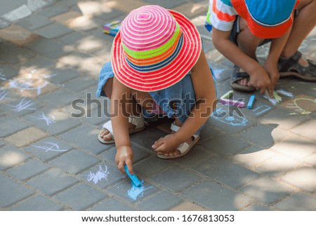 Little children draw with chalk on the pavement