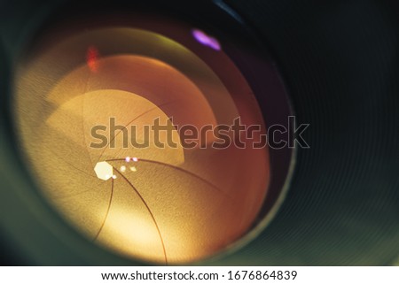 Beautiful camera lens with orange  light of glass. Background pattern for design.	