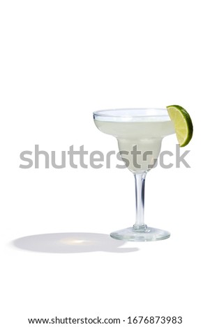 Daiquiri cocktail is contained in a margarita glass with a lime slice on the rim. The showy illustrative picture is made on the white background.