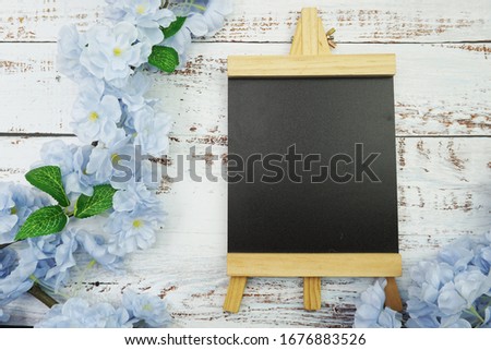 Empty Easel Space copy for text with Blooming Flowers on wooden background