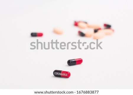 Black-red pills with sign coronavirus on white background. Concept vaccine against dangerous virus 