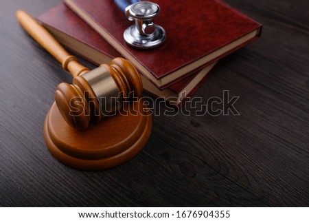 Gavel and stethoscope on wooden background, symbol photo for bungling and medical error. Medicine laws and legal, medical jurisprudence. Royalty-Free Stock Photo #1676904355