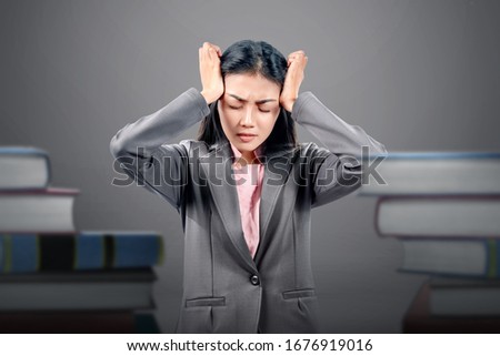 Asian businesswoman with headache expression with a stack of document background