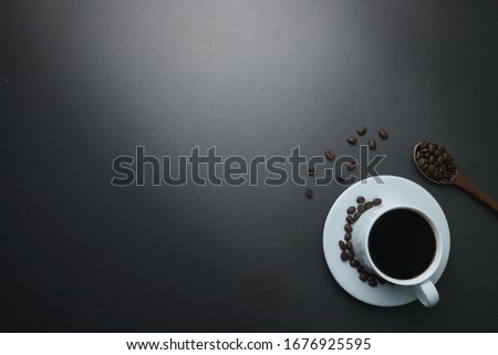coffee cup with coffee beans on black office desk. flat lay. fine art. copy space for your text