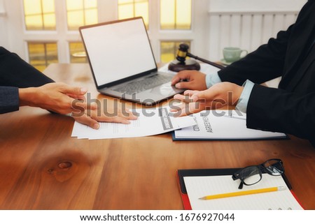 The lawyer submits a contract document to the client at table in office. Sign a contract business. Treaty of the law. Royalty-Free Stock Photo #1676927044