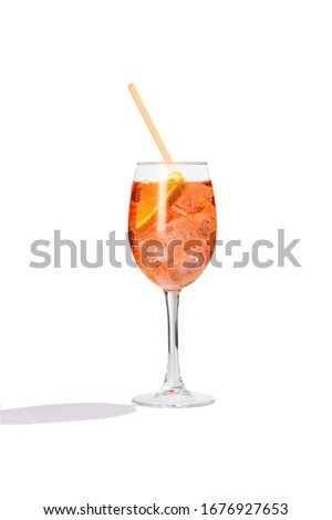 Aperol Spritz cocktail with a slice of orange, ice cubes and an orange straw is contained in a high glass on the long stem. The bright illustrative picture is made on the white background.