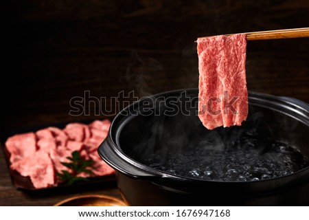 Japanese cuisine, Japanese beef shabu-shabu on wooden table Royalty-Free Stock Photo #1676947168
