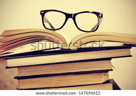 picture of a pile of books and eyeglasses, with a retro effect