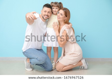 Family taking selfie near color wall